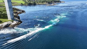 An aerial view of the powerful Saltstraumen maelstrom, with turbulent turquoise currents swirling near the bridge in Norway - Powered by Shutterstock - Get 15% off with code: PIKWIZARD15
