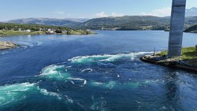 An aerial view of swirling maelstroms beneath the Saltstraumen bridge near Bodo, Norway, showcasing powerful tidal currents in the narrow strait - Powered by Shutterstock - Get 15% off with code: PIKWIZARD15