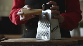 Grating hard cheese on metal kitchen grater. - Powered by Shutterstock - Get 15% off with code: PIKWIZARD15