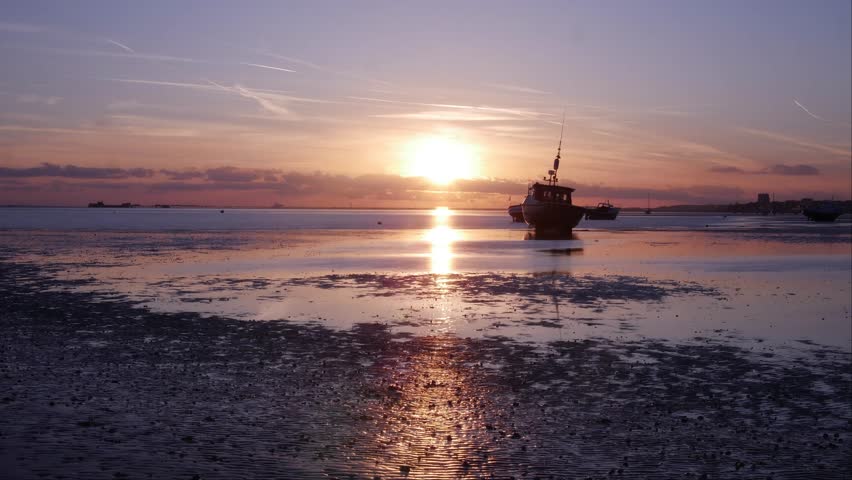 Sunset on beach with boat in foreground