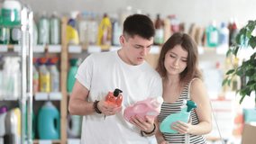 Spouses buy household chemicals in store, choose glass spray, liquid detergent and other cleaning products. Young family, shared routine tasks, shopping - Powered by Shutterstock - Get 15% off with code: PIKWIZARD15
