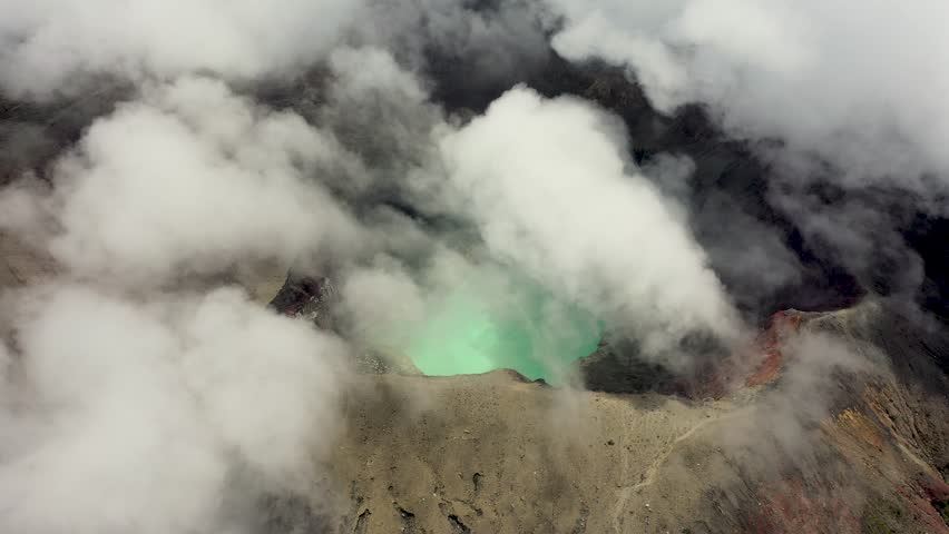 A scenic drone view of wisps of volcanic smoke rising from the summit against a dramatic sky in Santa Ana Volcano, El Salvador