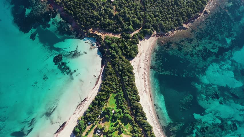 A scenic drone view with turquoise waters and a perfect crescent of sand in Rondinara Beach, Bonifacio, France