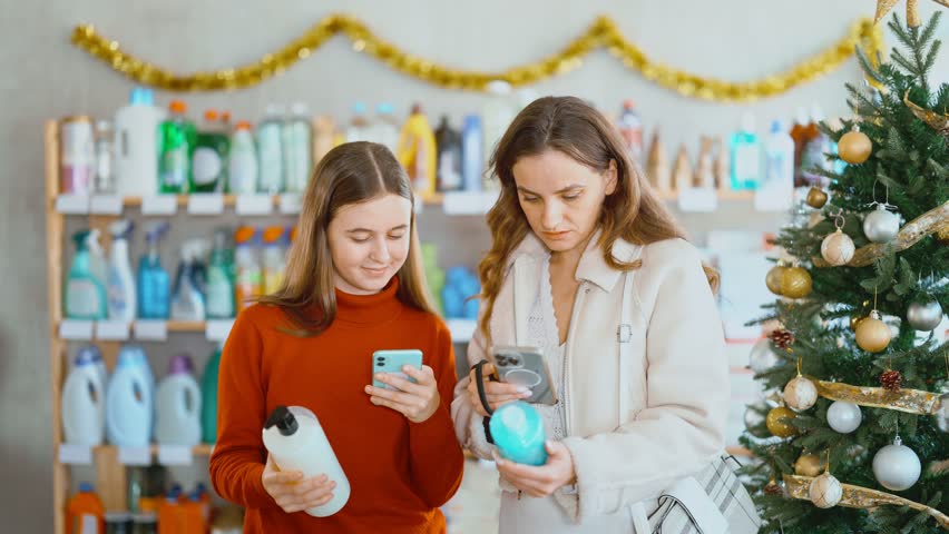 Woman with teen daughter scan barcode on shampoo or bath foam label, follows link to view product. Buyer reads customer review. 