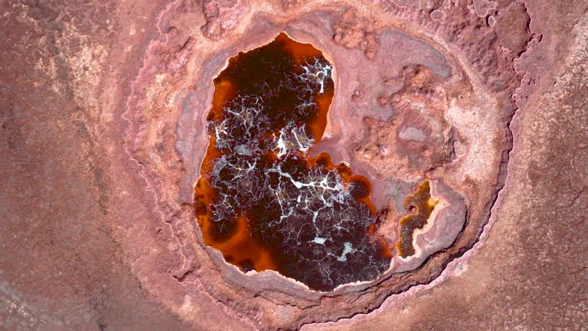 An aerial view of vivid red and yellow acid pools surrounded by mineral deposits in Ethiopia Dallol geothermal region