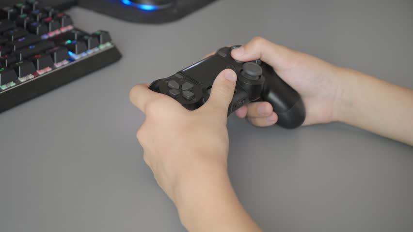 A child's hands making quick movements on a controller during intense gameplay. Developing a boy's reflexes, or the concept of overstimulation from youth action games. - Powered by Shutterstock - Get 15% off with code: PIKWIZARD15