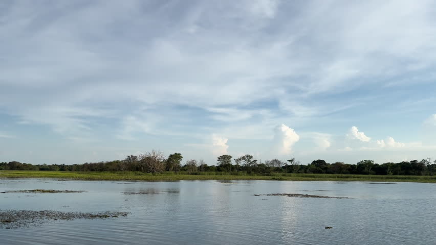 Beautiful landscape featuring a calm water body under a blue sky with soft clouds, representing peacefulness and tranquility in nature