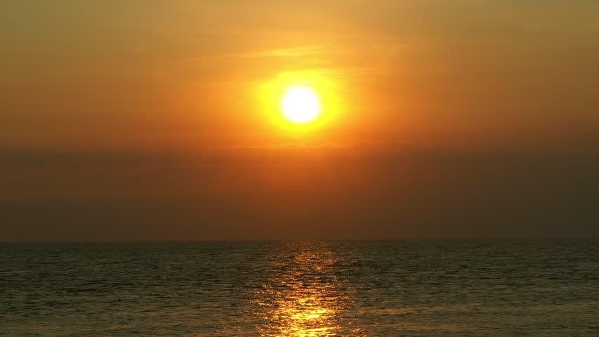 Beautiful infinite sea in the rays sunset touches the horizon
