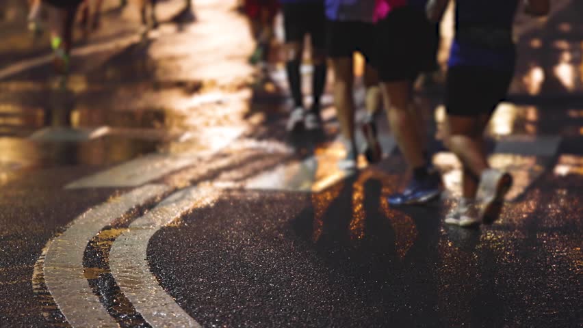 Night marathon runners crowd, sportsmen participants start running the half-marathon in the night city streets, crowd of sportswomen joggers in motion, group athletes outdoor training competition 