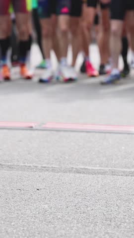 Marathon runners crowd, sportsmen participants start running the half-marathon in the city streets, crowd of sportswomen joggers in motion, group athletes outdoor training competition in summer day
