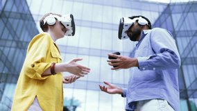 A diverse couple, wearing VR headsets, shakes hands in front of a modern building, symbolizing a tech collaboration. - Powered by Shutterstock - Get 15% off with code: PIKWIZARD15