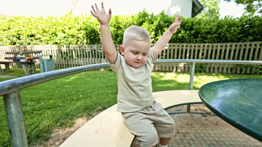 Little European boy rides on a swing on a playground. Child plays outdoors. Swing on a playground.