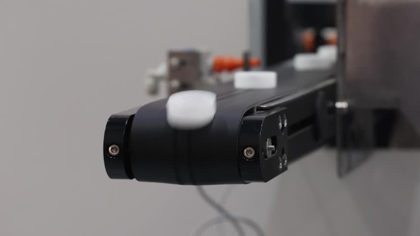 Caps making. Automated production line with industrial machines sorting and transporting plastic caps on a conveyor system. Manufacturing tech process for packaging pharmaceuticals or food industry.