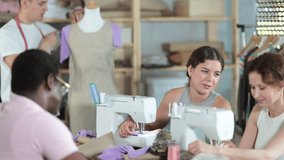 Positive interested female fashion design students stitching on machines and friendly talking, sharing sewing tips in hands-on workshop while male classmate adjusting garment on mannequin - Powered by Shutterstock - Get 15% off with code: PIKWIZARD15