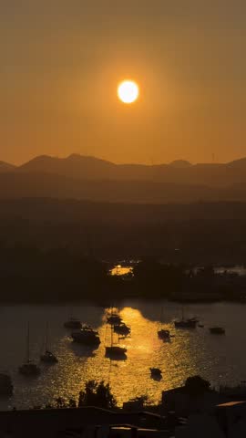 scenic moment of boats silhouetted against a shimmering body of water, at sunrise, given the golden reflections on the water