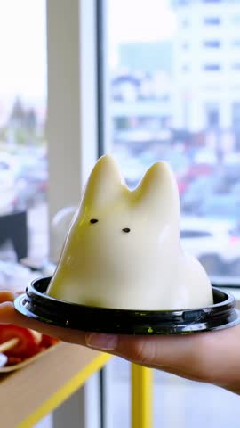 Playful mousse jelly dessert in a cafe, captured in a series of frames, highlighting its charming movement and textures as hands engage with the delightful treat in a seamless action flow
