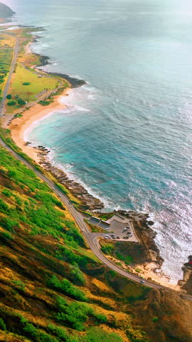 Asphalt highway along the slopes of Koko volcano on the coast of blue waters with waves of the Pacific Ocean. Aerial view from above to the observation deck. Hawaii. Vertical video.