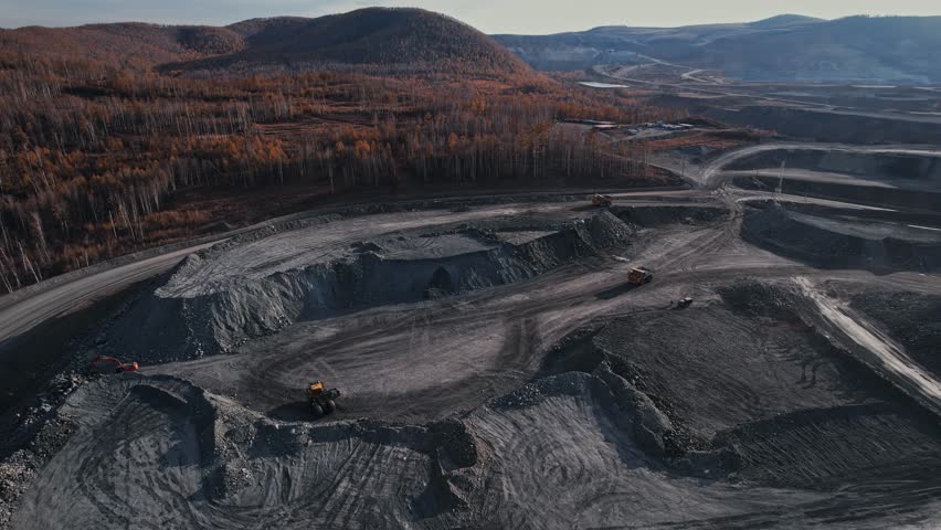 Open pit mine with dump truck aerial view by drone, extractive industry for gold ore.