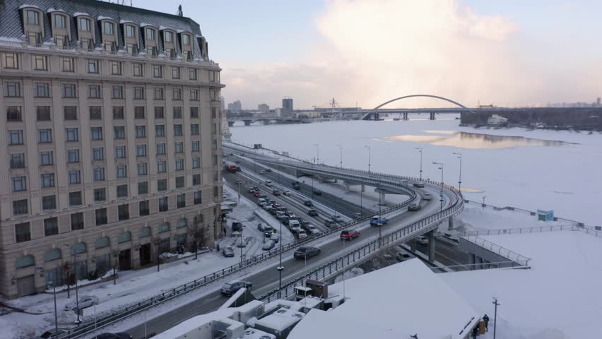 Modern city interchange junction. Aerial drone view of busy cars traffic on the road. Picturesque urban landscape on a winter day.