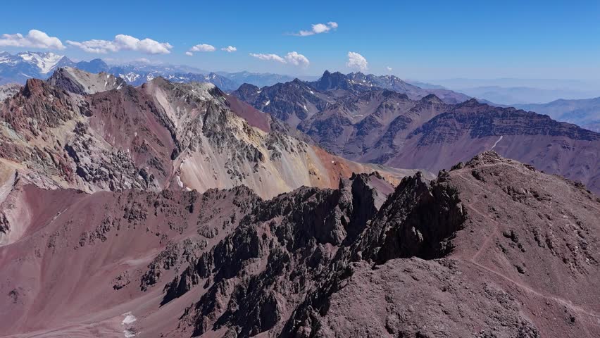 Drone shot of the Andes mountains near Aconcagua, Argentina. The dry, rocky slopes and sharp ridges extend far into the horizon, highlighting the region