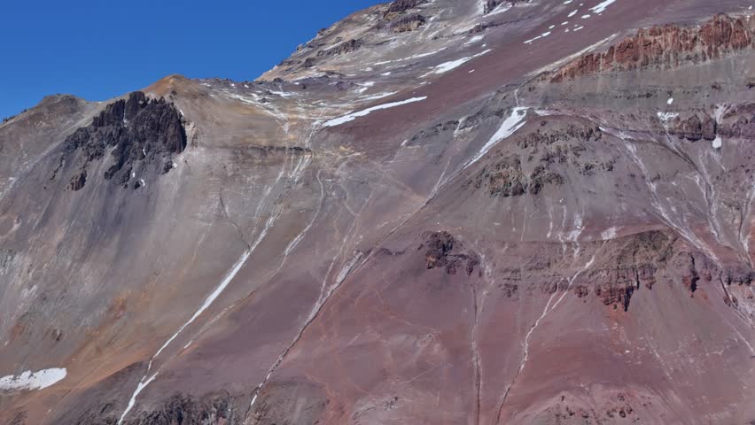 Remote mountain valley with glaciers and rugged terrain in Argentina. The terrain showcases steep slopes, rocky outcrops, and snow patches.