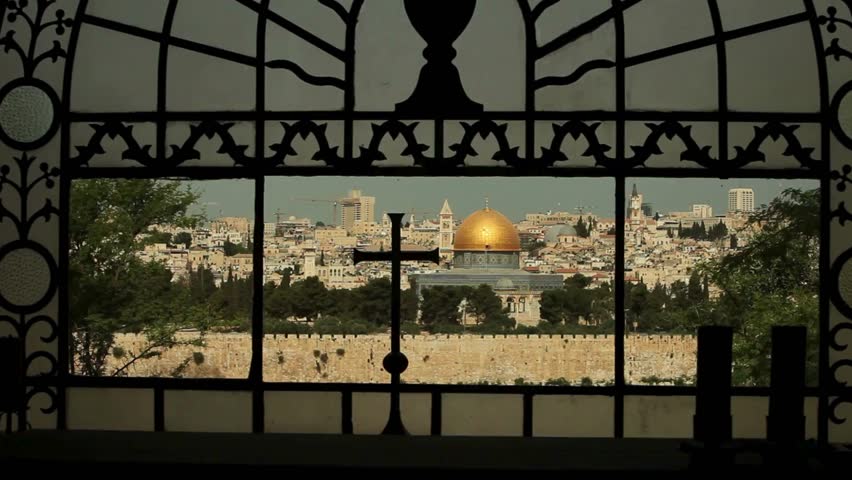 View of the dome of the rock in jerusalem through a window with a cross