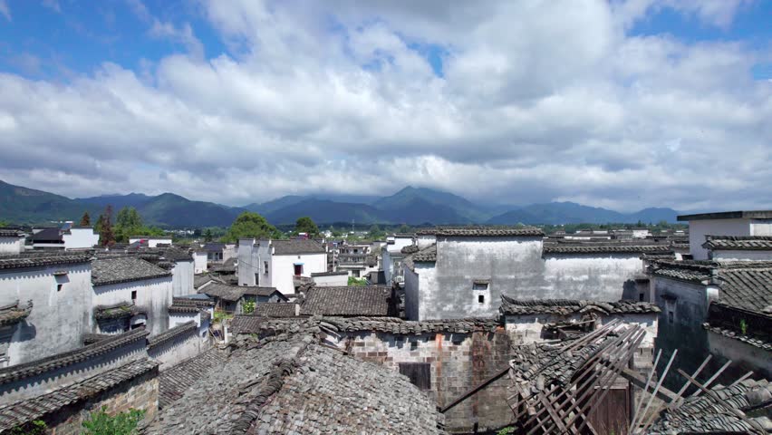 Drone view villages and farmlands among green mountains, high angel view rural landscape in autumn day, 4k real time footage b roll shot, Nanping village, Yixian, Anhui, China.