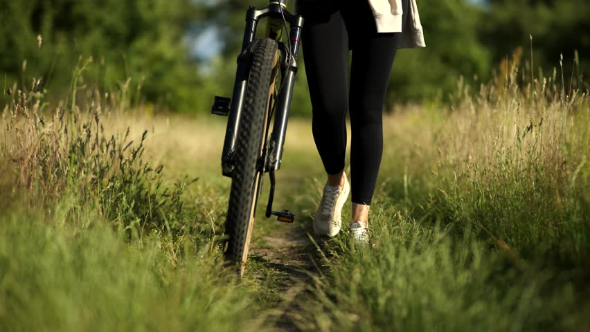 Cyclist Biking On Rural Path Through Field, Woman On Mountain Bike Adventure. Outdoor Sport Activity Cycling, Fitness Training In Nature. Cyclist Trail Riding. Off-Road Mountain Biking. Cyclist Bike