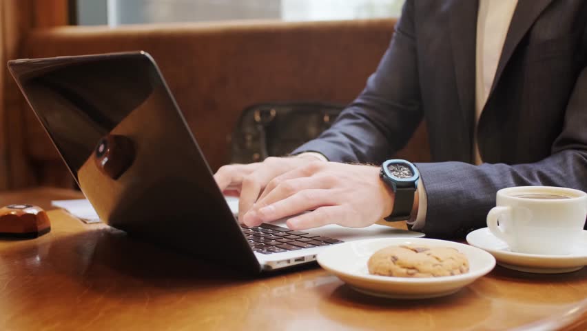 Businessman working on laptop with coffee cup, representing modern office, remote work, and productivity.