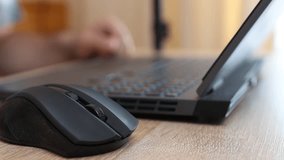 Close-up of hands using a laptop keyboard and mouse on a wooden desk. Work, internet browsing, and technology concept in modern everyday life. - Powered by Shutterstock - Get 15% off with code: PIKWIZARD15