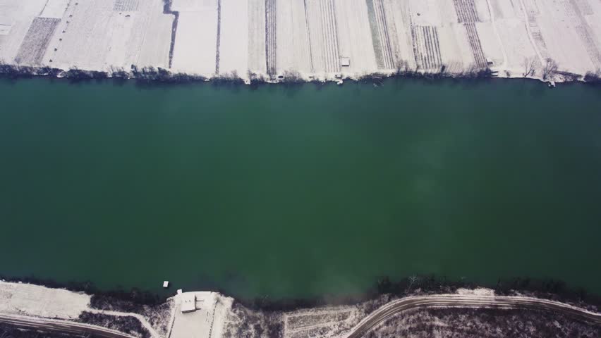 Exploring the serene winter landscape along the river and fields in a snowy setting