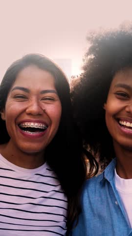 Happy afro latina and Brazilian friends smiling together outdoor. Vertical video