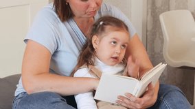  Small Caucasian child learns to read with help from a caregiver. Preschool development in a warm and supportive space. Close up. - Powered by Shutterstock - Get 15% off with code: PIKWIZARD15
