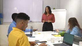 Businesswoman leads a presentation to her team in a modern office, engaging in discussion and collaboration - Powered by Shutterstock - Get 15% off with code: PIKWIZARD15