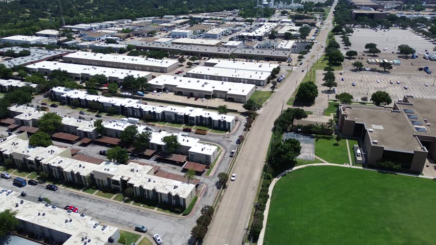 Low-rise flat roofed commercial and industrial buildings with wide parking lots along TI Boulevard, logistics, office use, tech services, forming vital part of Richardson Telecom Corridor, Texas. USA