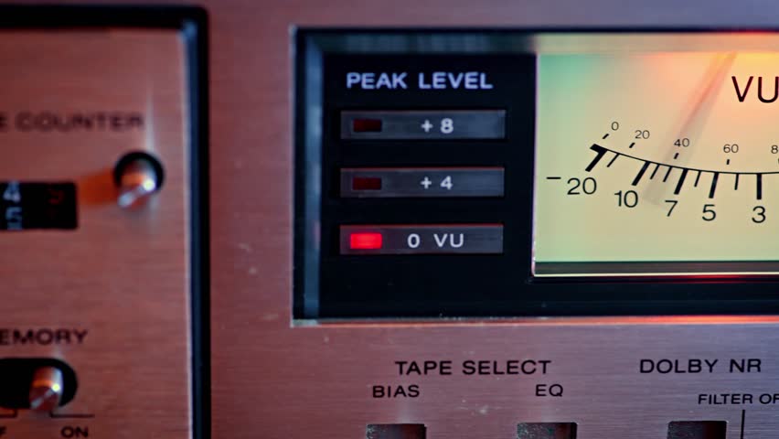 Video panning across two analog VU meters on retro stereo equipment. The needles bounce rhythmically with audio playback, capturing classic hi-fi style and nostalgic sound recording details.
