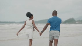 Romantic Black Couple Enjoying a Walk by the Ocean, African American Lovers Smiling, Holding Hands, and Sharing a Peaceful Beach Moment on Holiday - Powered by Shutterstock - Get 15% off with code: PIKWIZARD15
