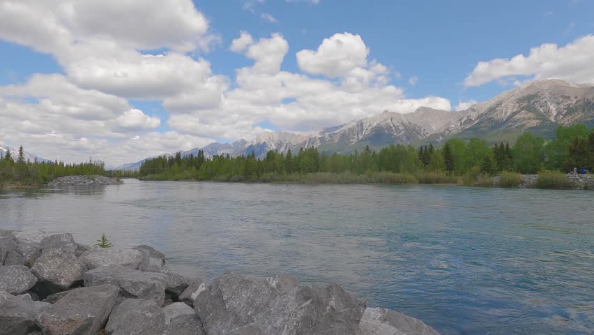 The green water reflects the vibrant greenery, showcasing the untouched natural beauty of the wilderness. This cinematic scene perfect for projects related to eco-tourism, environmental conservation	
