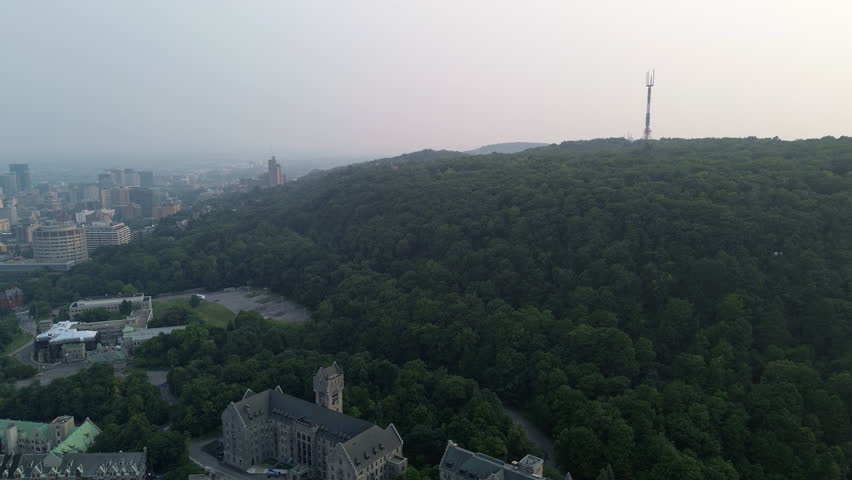 Drone view of Mont Royal in Montreal, covered in atmospheric haze from nearby wildfires during summer.
