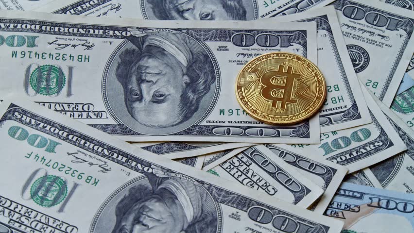 Rotating Bitcoins On A Pile Of Hundred Dollar Bills Represent Transition From Traditional Banking To Decentralized Currency Systems, Secure Payments, And Future Finance Models.