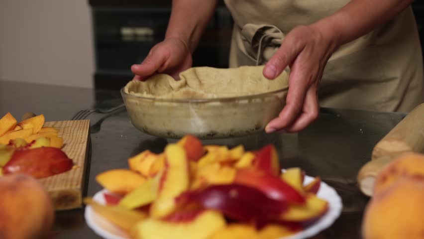 Preparing a Homemade Peach Pie with Fresh Ingredients in the Kitchen