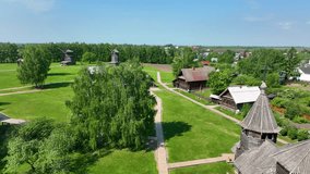 An aerial view of an ethnographic open-air museum, featuring traditional log cabins, wooden boardwalks, and historic windmills on a beautiful sunny day in the countryside - Powered by Shutterstock - Get 15% off with code: PIKWIZARD15