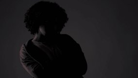 Young African-American man with crossed arms looking down posing for fashion studio portrait - Powered by Shutterstock - Get 15% off with code: PIKWIZARD15