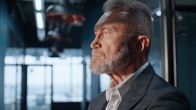 Thoughtful senior businessman standing in modern company hall in elegant suit closeup. Gray-hair corporate owner touching beard thinking on business growth. Serious man executive pondering goals. - Powered by Shutterstock - Get 15% off with code: PIKWIZARD15