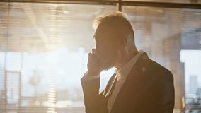 Silhouette nervous director calling cellphone gesturing emotionally in evening sunlight corridor closeup. Furious elderly businessman quarrelling in smartphone in hall. Mature manager yelling in phone - Powered by Shutterstock - Get 15% off with code: PIKWIZARD15