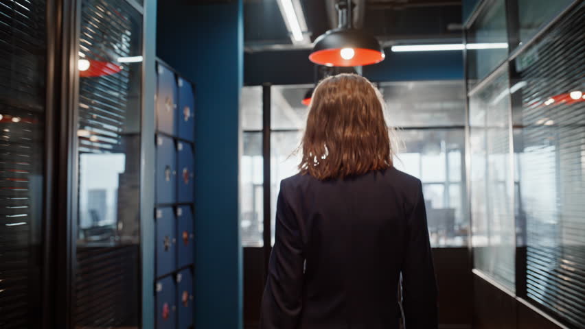 Back view businesswoman walking hall modern center closeup. Elegant woman manager hurrying on office work. Successful lady employee going at corridor contemporary building. Busy corporate professional