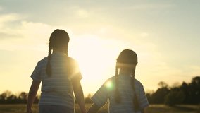 Two child sister girl kid holding hands field sunset, siblings watching sunset together, children bonding nature, sunset stroll kid, friends enjoying summer evening, kid striped shirts sunset - Powered by Shutterstock - Get 15% off with code: PIKWIZARD15