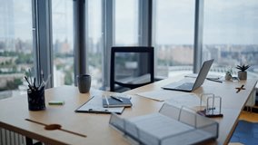 Empty corporate workspace with laptop in bright modern office with city view. Documents coffee cup placed at professional wooden desk. Workplace interior with panoramic window for productive workflow. - Powered by Shutterstock - Get 15% off with code: PIKWIZARD15