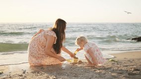 Family enjoys a sunny day building sandcastles on the beach next to the ocean during the golden hour of late afternoon - Powered by Shutterstock - Get 15% off with code: PIKWIZARD15