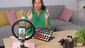 Asian beauty influencer presenting makeup products to her followers during a livestream from her home studio - Powered by Shutterstock - Get 15% off with code: PIKWIZARD15